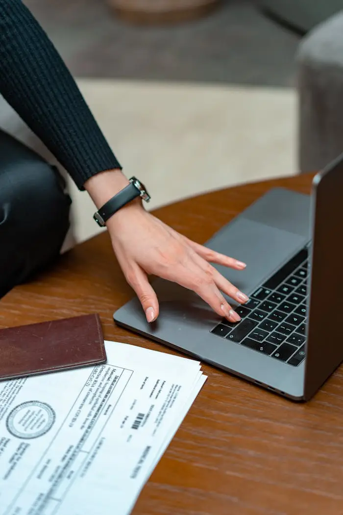 The Art of Drawing Readers In: Your attractive post title goes here Close-up of a person typing on a laptop with legal documents on a table, showcasing work and technology integration.